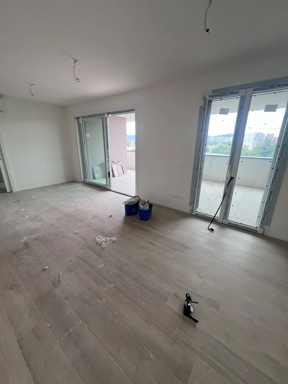 Stanza con parquet chiaro prima della pulizia post-ristrutturazione