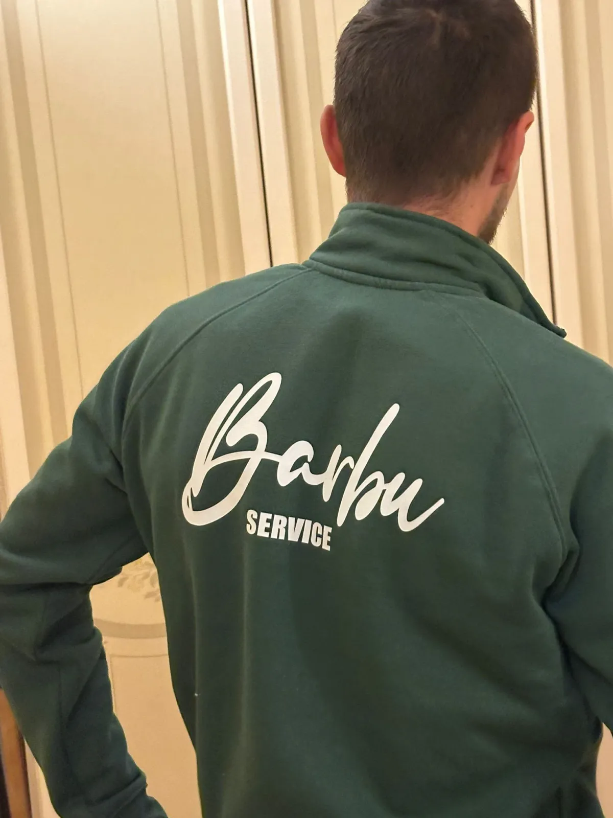 Operatore Barbu Service di spalle con la felpa verde brandizzata dell'azienda